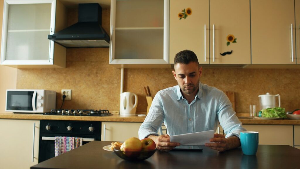 Person reviewing insurance documents with a highlighter, calculator, receipts, and a home inventory notebook.